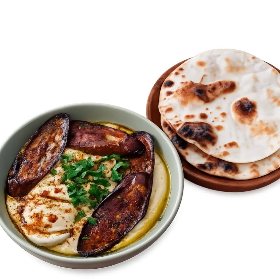 Hummus sabich topped with fried eggplant and egg, served with pita.