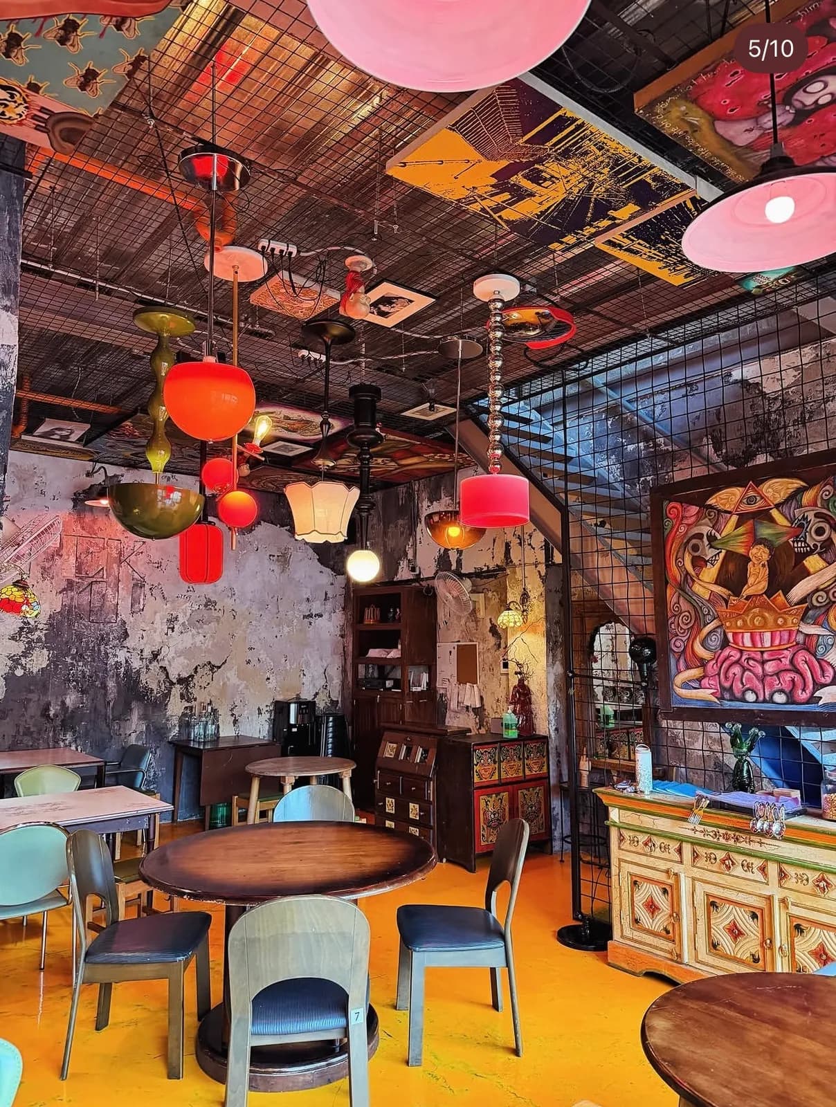 Colorful dining room with round tables, hanging lamps and wall art