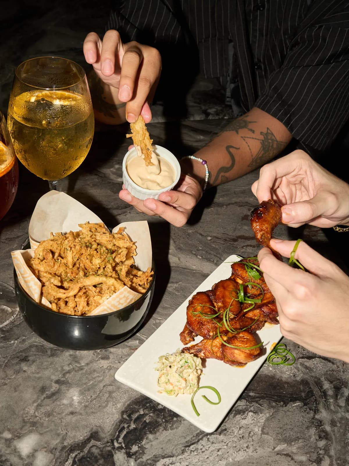 Mushroom fritters, smoked buffalo wings and drinks on a table.