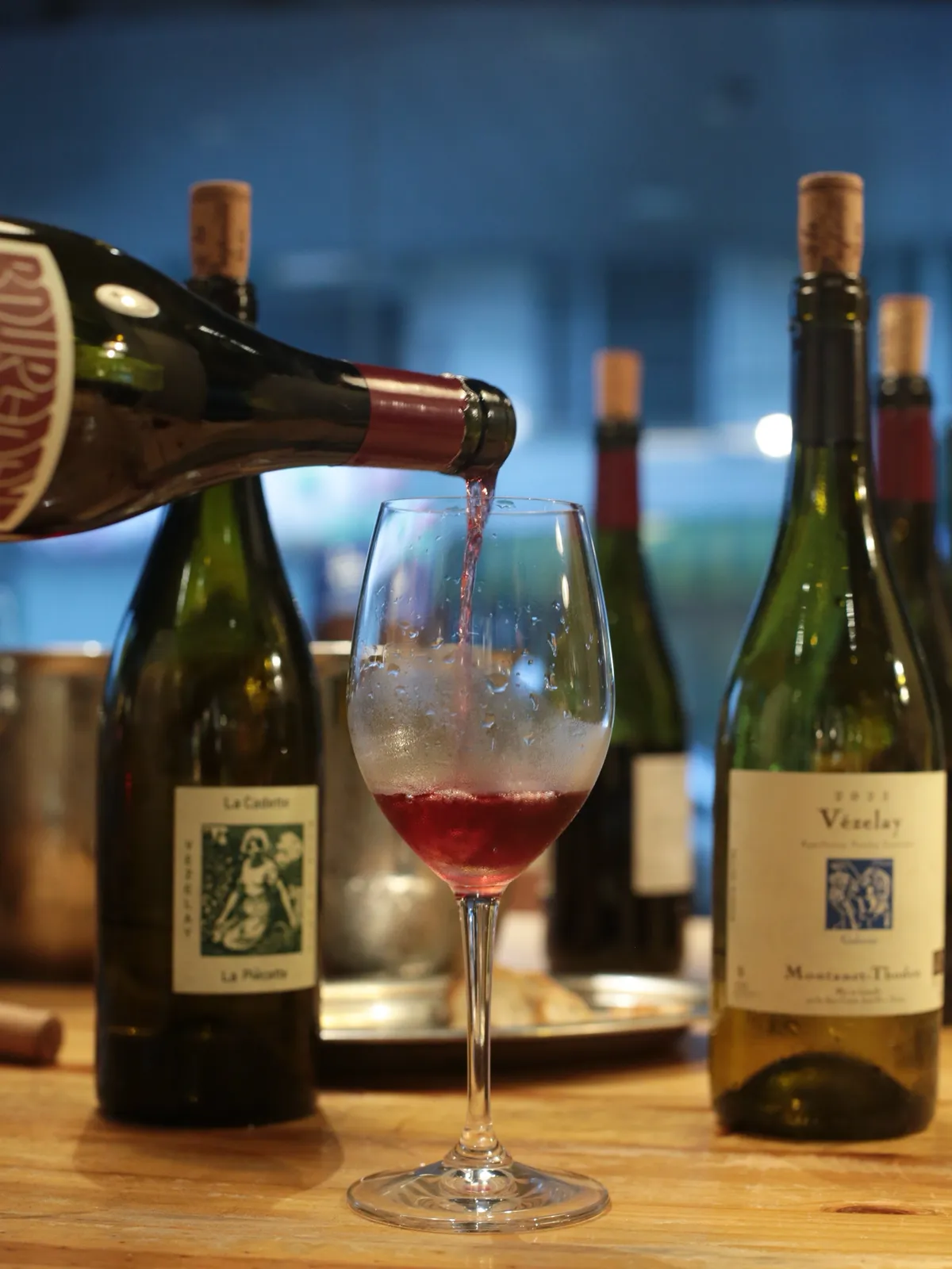 Red natural wine being poured into a glass at the bar