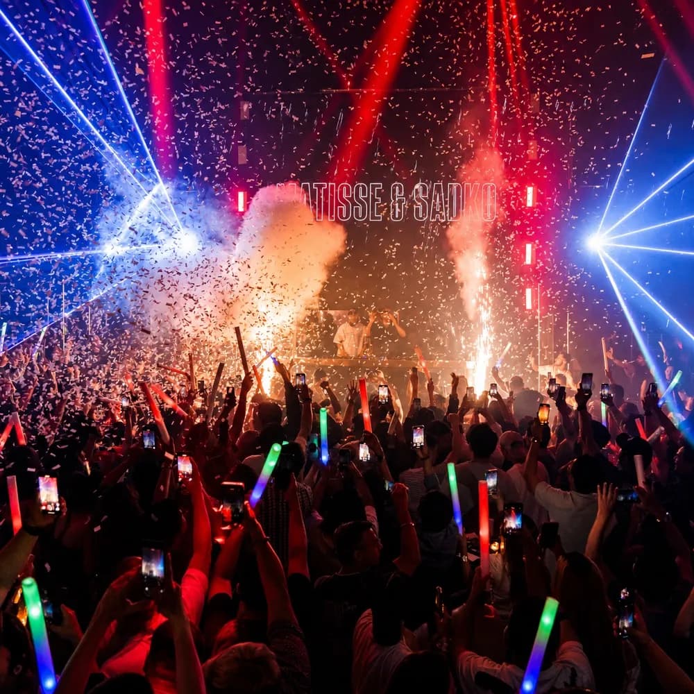 Packed Octopus dance floor under red beams, lasers, confetti and stage effects.