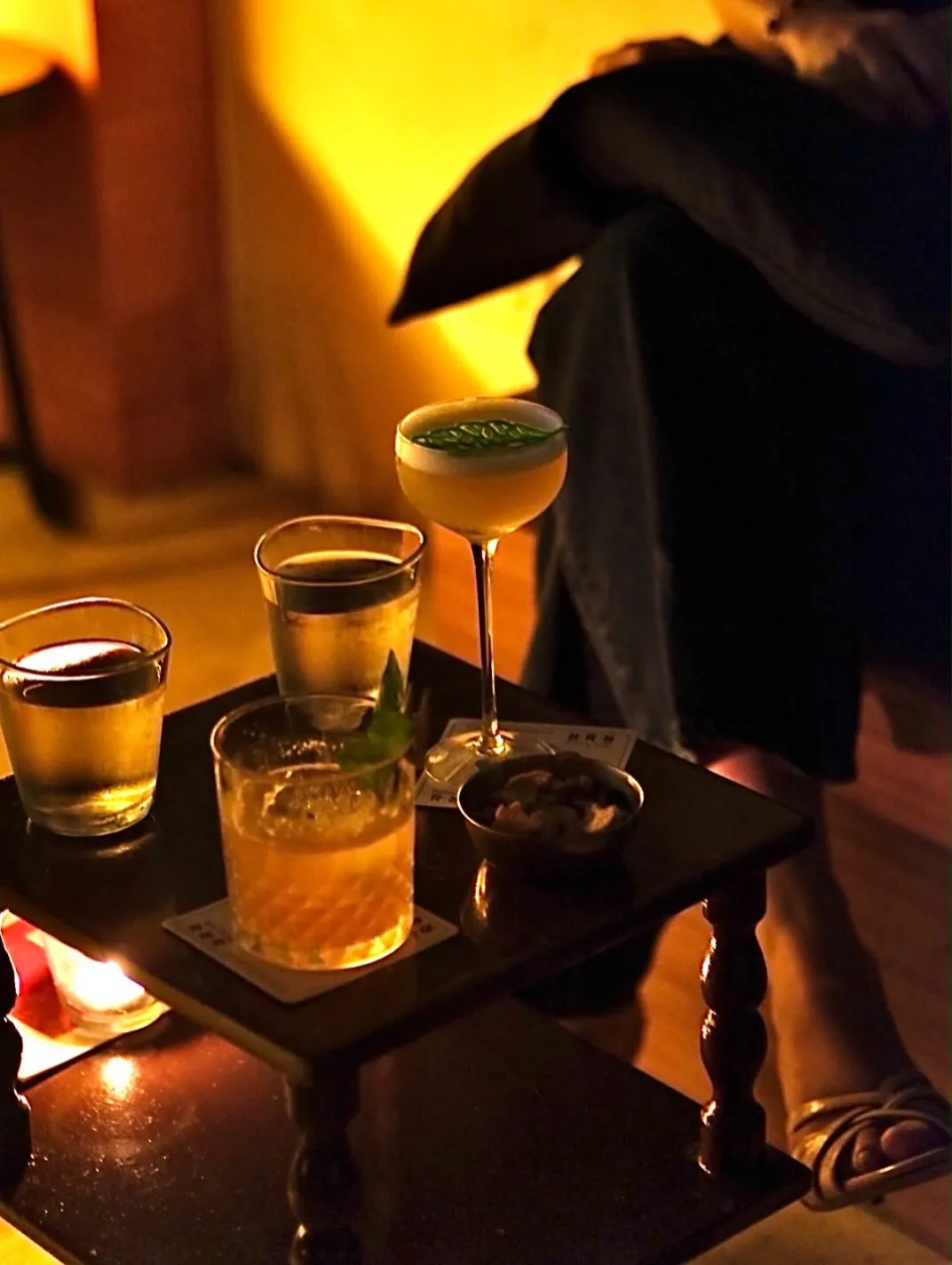 Tray of cocktails glowing under warm bar lighting