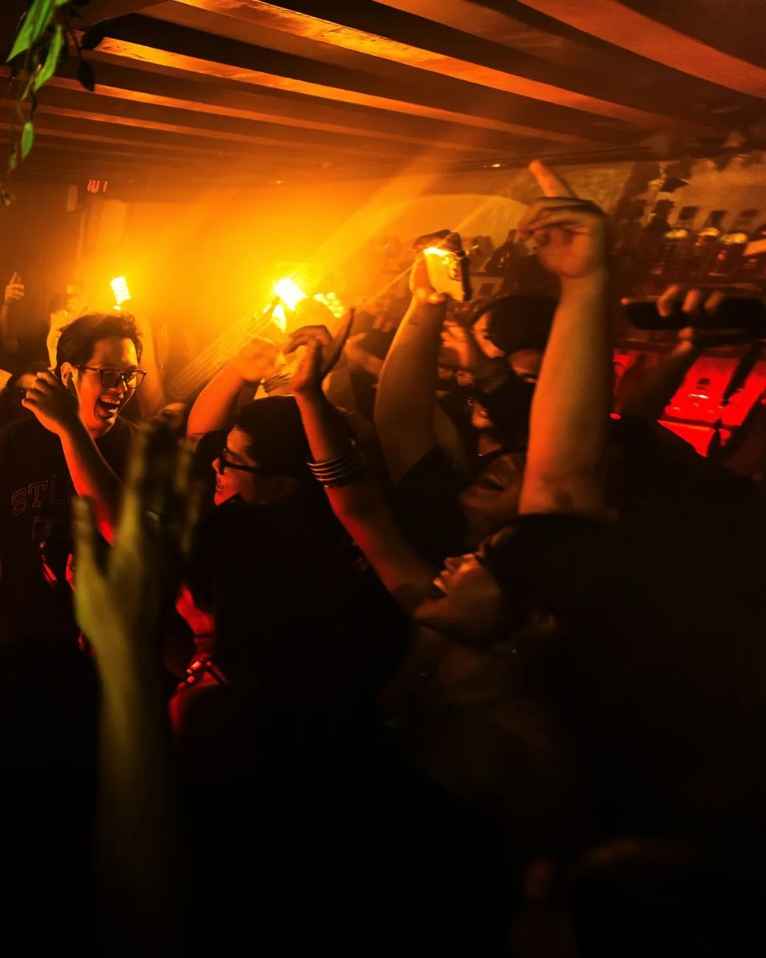 Club guests dancing under bright amber lights at Xin Chào.