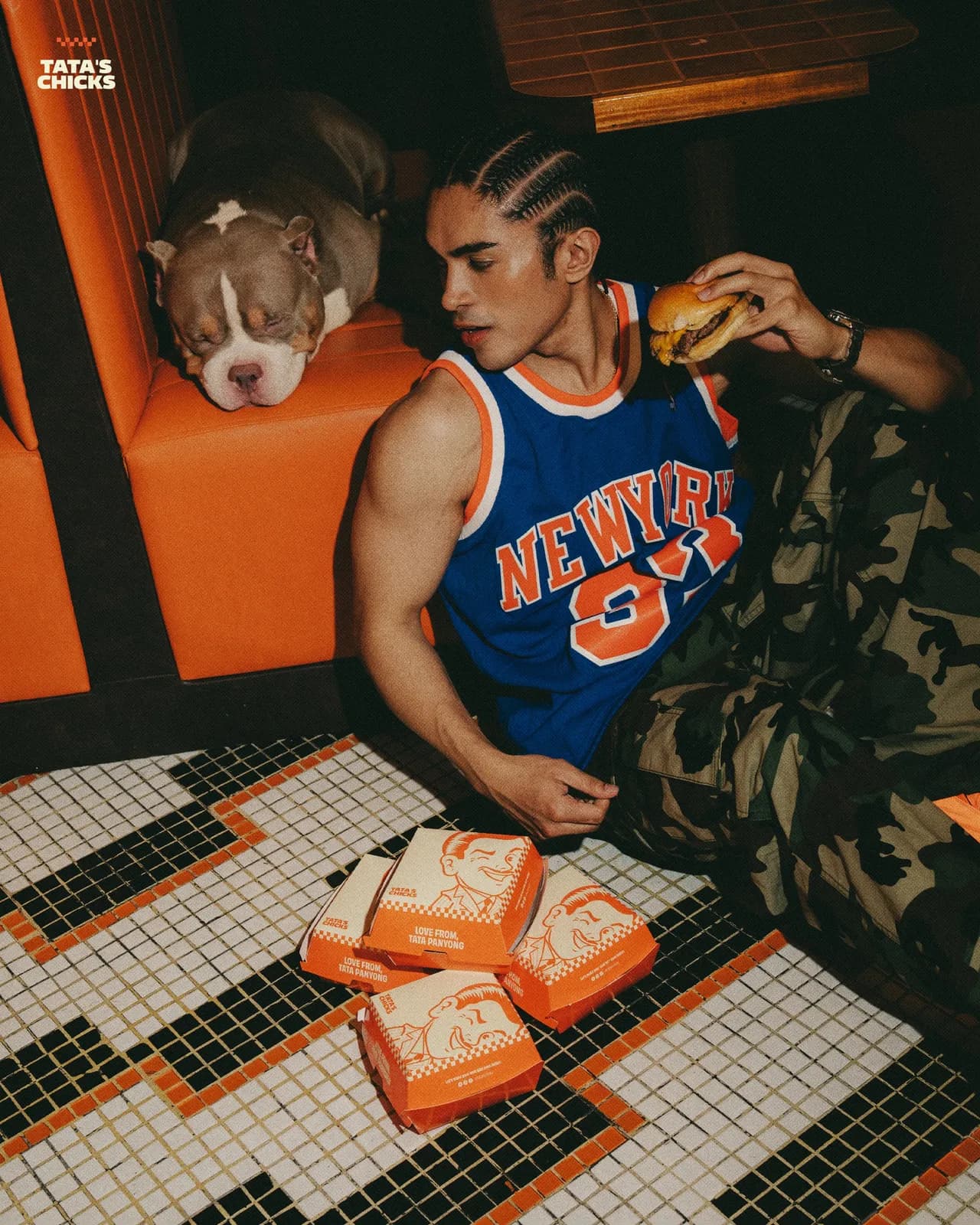 Cheeseburger and stacked orange takeout boxes on the tiled floor by the booths