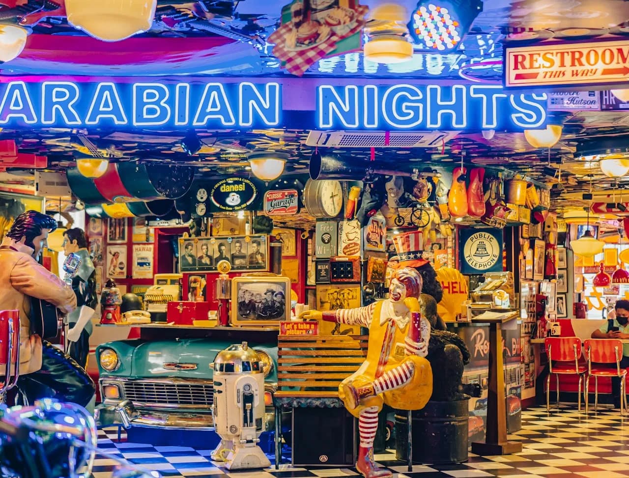 Colorful diner interior with a vintage car booth, neon and memorabilia.