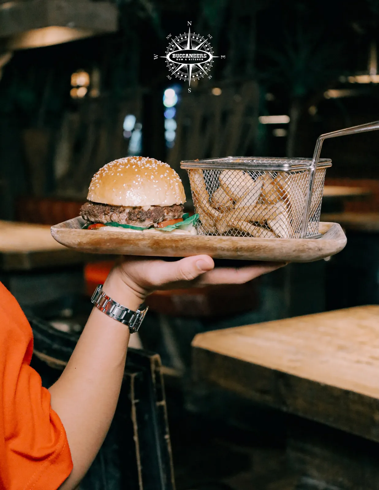 Burger and fries on a wooden tray inside the wood-panelled bar.