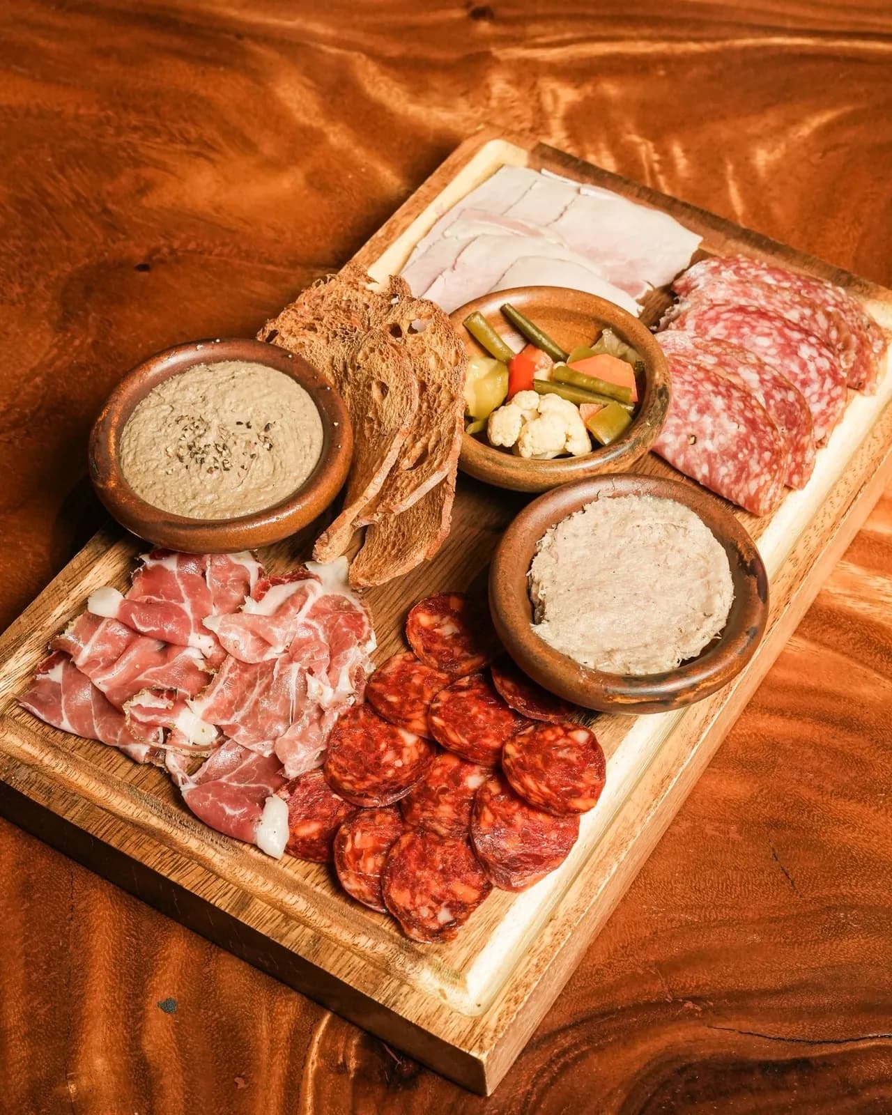 Charcuterie board with cold cuts, pâté, pickles and bread