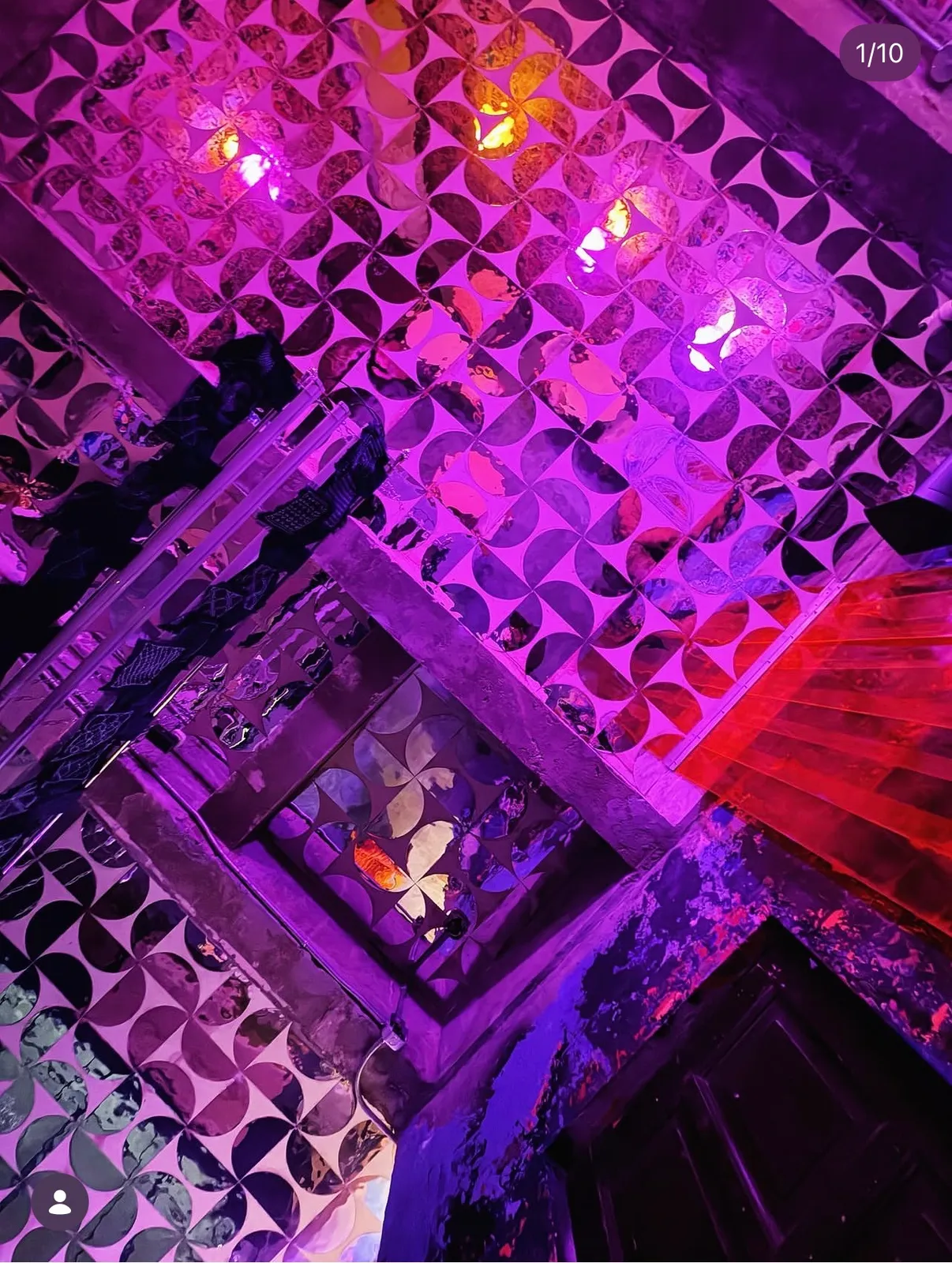 Purple-lit bar ceiling with patterned mirrored panels